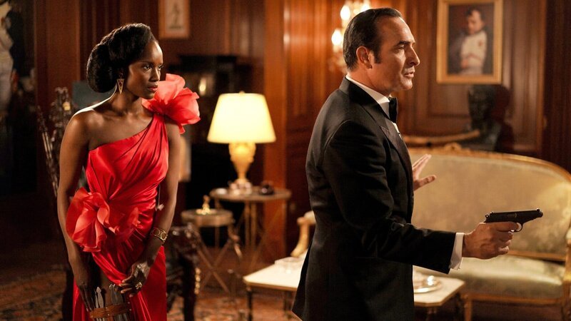 1981 verschlägt es den französischen Spion OSS 117 aka Hubert Bonisseur de La Bath (Jean Dujardin) nach Afrika, wo er in der schönen Zéphyrine (Fatou N’Diaye) eine vermeintliche Mitstreiterin findet. – Bild: ZDF und Christophe Brachet./​Christophe Brachet